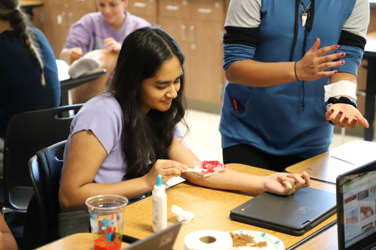 Seemrah Islam creating a fake wound while in Medical Terminology. A project meant to further her knowledge into the skin.